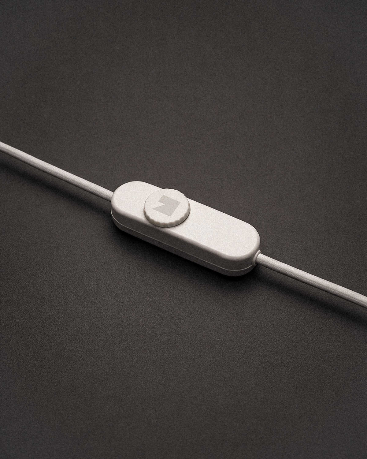 White cable with dimmer on a wooden surface with books in the background