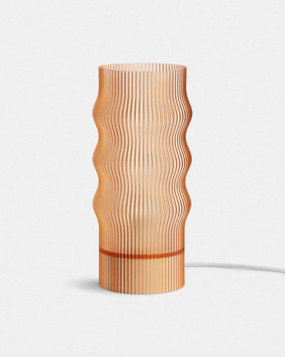 Amber table lamp with wavy design on a white background