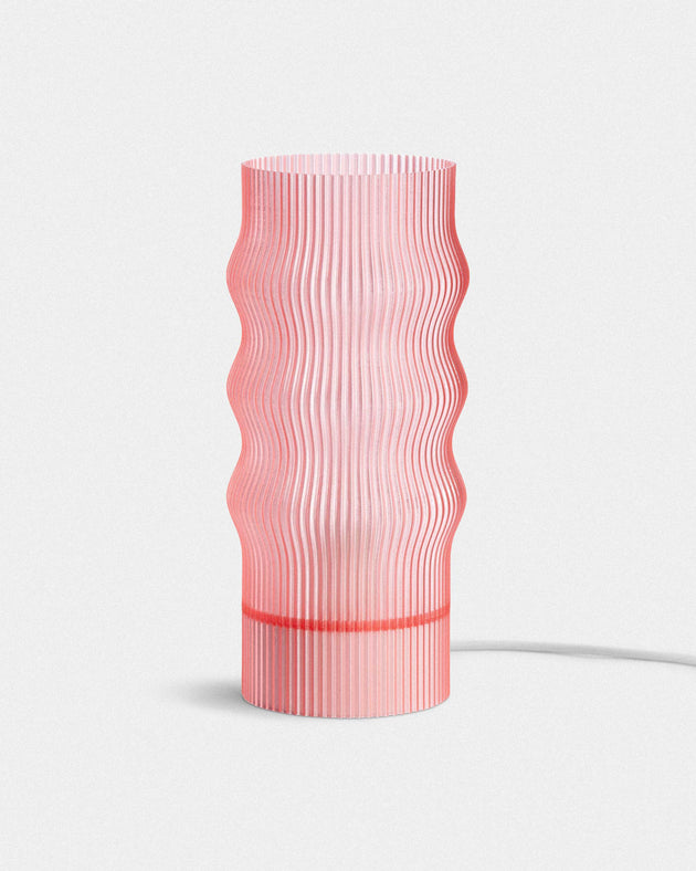 Pink textured table lamp on a white background